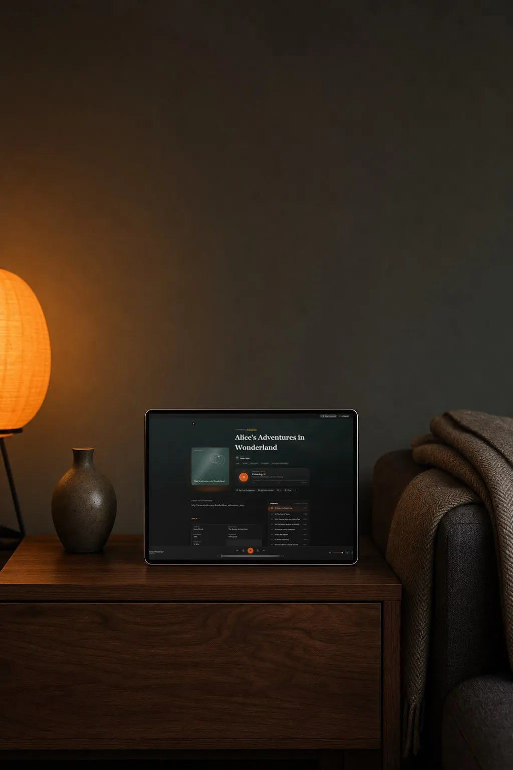 A tablet on a bedside table with an audiobook playing